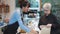 Customer senior woman ordering food and coffee with barista at the cafe, staff serving coffee and food for customer takeaway.