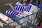 Customer shopper pushing a shopping trolley cart full of plastic carrier bags at its Tesco Extra supermarket