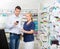Customer Using Mobile Phone While Chemist Holding