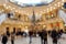 Customers in Christmassy Shopping Mall in Front of Christmas Tree Blurred Background