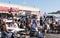 Customers sitting at tables enjoying food truck food at local fair