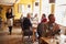 Customers at tables and waitress in busy restaurant interior