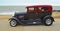 Customised Red and Black Classic Hotrod parked on seafront promenade.