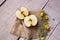 Cut Apple on fabric and wood with flowers and seeds