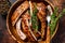 Cut BBQ grilled lamb rack spareribs in a wooden plate. Dark background. Top view