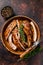 Cut BBQ grilled lamb rack spareribs in a wooden plate. Dark background. Top view