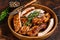 Cut BBQ grilled pork rack spareribs in a wooden plate. Dark background. Top view