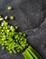 The cut bundle of green onions on a background of black slate. Space for text.