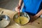 A cut child prepares dough in metal bowls. Without a face