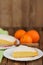 Cut clementine pie with clementines and knife on wooden background