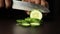 Cut the cucumber. Female chief cook chopping vegetables, cooking delicious fresh salad for lunch