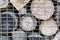 Cut and dried log pile behind the metallic mesh. Screen close-up, background.