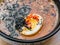 Cut egg, sesame seeds, nori in Hot miso soup in black and white plate on table. Top view. Dish of Japanese cuisine in an Asian res