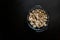 Cut forest champignon mushrooms in glass bowl on dark background or black wooden table.