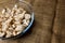 Cut forest champignon mushrooms in glass bowl standing on table covered with sackcloth.