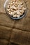 Cut forest champignon mushrooms in glass bowl standing on table covered with sackcloth.