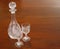 Cut-glass crystal decanter and goblet wine glasses on mahogany dining table