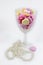 Cut glass wine glass filled with pastel candy hearts with string of pearls lying at bottom