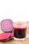 Cut half beetroot and fresh beet juice in glass on wooden table, white background.