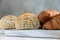 Cut in half croissant with inside texture and thin crisp layers on wooden board, light concrete background. Delicious french