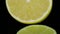 Cut in half fresh lemons and limes rotating in a circle, black background, and space for text. Close up
