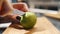 cut lemon. cooking. close-up. female hands cut fresh lemon in half with a knife, on a wooden plank