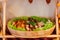 Cut meat lies on the wooden plate covered with greenery