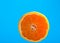 Cut orange. Orange juice drips. Half the fruit. Fresh citruses. Oranges on a blue background. Juicy fruit. Naral vitamins.