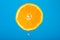Cut orange. Orange juice drips. Half the fruit. Fresh citruses. Oranges on a blue background. Juicy fruit. Naral vitamins.