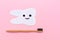 Cut out tooth of felt with cartoon smile and bamboo toothbrush. Pink background. Flat lay. Concept of health care