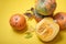 cut pumpkin and different pumpkins on yellow background, top view, autumn leaves and pumpkins with growths on the peel