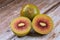 Cut red Kiwifruit Chinese gooseberry - genus Actinidia and whole berry on wooden table top