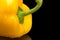 Cut shot of yellow bell pepper isolated on black with water drop