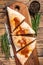 Cut and sliced Calzone closed pizza with ham and cheese on wooden board with hot tomato sauce. wooden background. Top