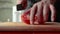 Cut the tomato into cubes on a wooden cutting board for salad