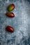 cut and uncut mangoes, on a dark, blue, cement, metal, marble and stone background