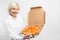 Cut view of grandma holding a big box of tasty pizza. She likes the junk food despice it is not healthy for people. Lady