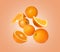 Cut and whole oranges flying on peach background