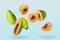 Cut and whole papaya fruits falling on pale light blue background