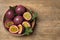 Cut and whole passion fruits maracuyas on wooden table, top view. Space for text