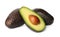 Cut and whole ripe avocadoes on white background