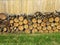 Cut wood stacked along brown wooden fence