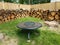 Cut wood stacked along brown wooden fence and fire pit