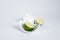 Cut â€‹â€‹halves of lime in a broken half of a ceramic small platter on a white back