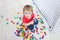 Cute 1 years blue-eyed baby girl plays multicolored meccano at h
