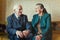 Cute 80 plus year old married couple posing for a portrait in their house. Love forever concept