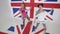 Cute active girls look at camera and dance in white studio with big UK flag