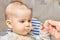 Cute adorable baby eating porridge with a spoonful of the concept of proper nutrition