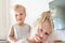 Cute adorable blond caucaian little sister hugging her toddler brother.couple of cheerful sibling playing indoor. Cute girl and