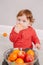 Cute adorable Caucasian baby boy eating citrus fruit. Finny child eating healthy organic snack. Solid finger supplementary food